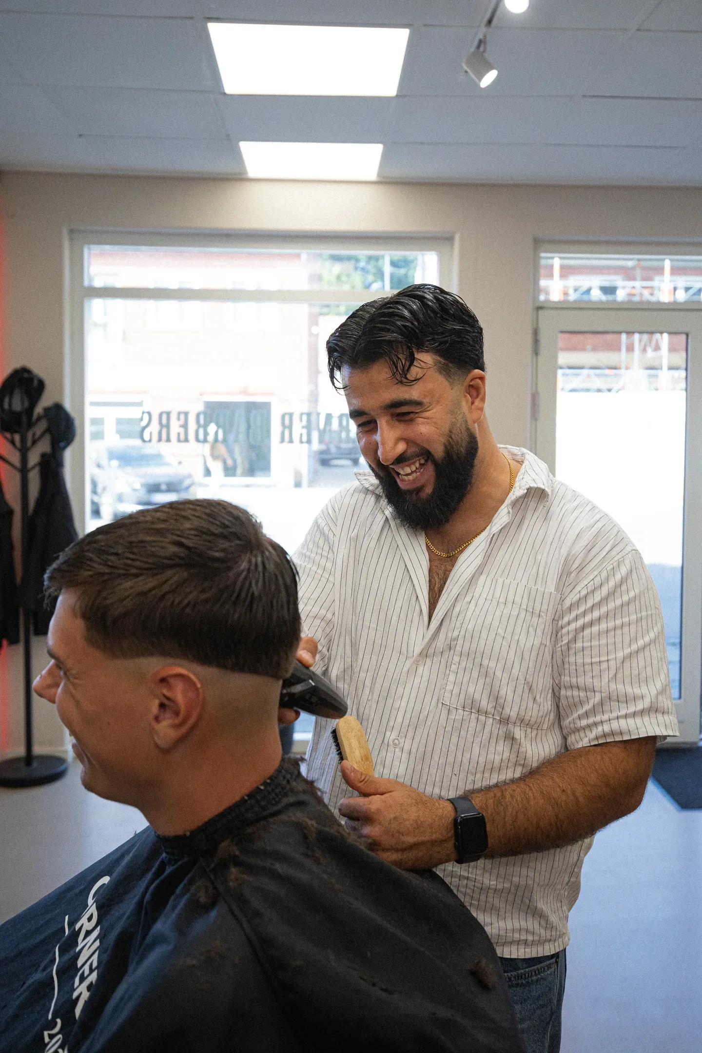 Sarfraz klipper en kunde hos Corner Barbers i Rønne